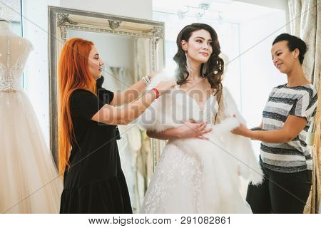 Beautifu bride choosing wedding dress in a wedding salon