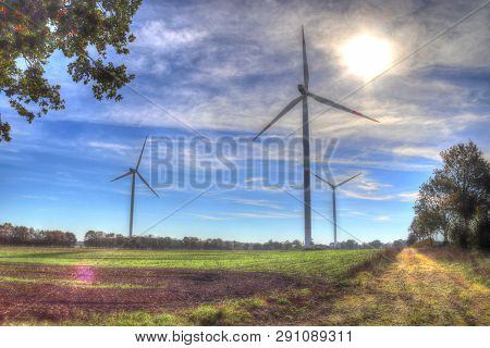 View On Alternative Energy Windmills In A Windpark In Northern Germany In Front Of A Blue Sky