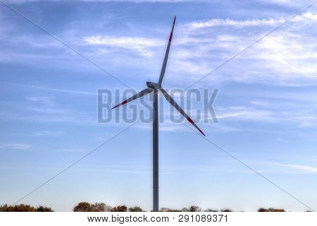 View On Alternative Energy Windmills In A Windpark In Northern Germany In Front Of A Blue Sky