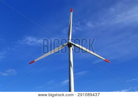 View On Alternative Energy Windmills In A Windpark In Northern Germany In Front Of A Blue Sky
