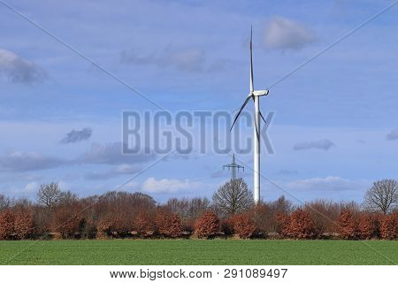 View On Alternative Energy Windmills In A Windpark In Northern Germany In Front Of A Blue Sky