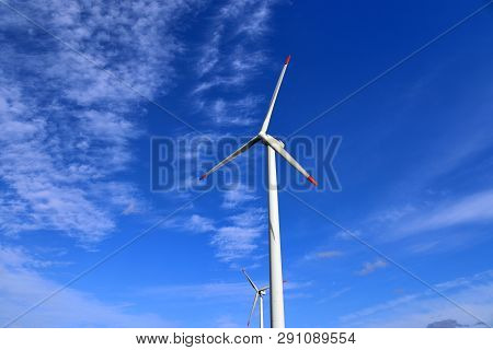 View On Alternative Energy Windmills In A Windpark In Northern Germany In Front Of A Blue Sky