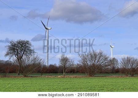 View On Alternative Energy Windmills In A Windpark In Northern Germany In Front Of A Blue Sky