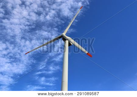 View On Alternative Energy Windmills In A Windpark In Northern Germany In Front Of A Blue Sky