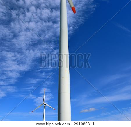 View On Alternative Energy Windmills In A Windpark In Northern Germany In Front Of A Blue Sky