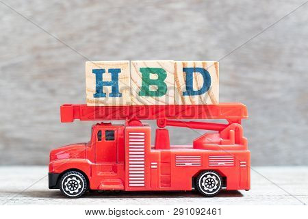 Red Fire Truck Hold Letter Block In Word Hbd (abbreviation Of Happy Birthday) On Wood Background