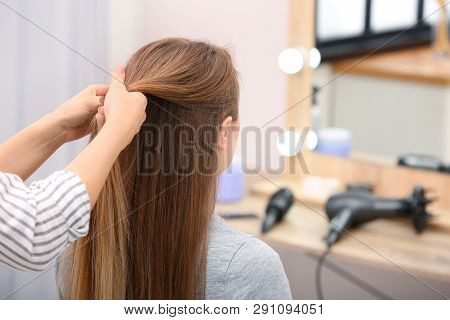 Professional Coiffeuse Braiding Client's Hair In Salon
