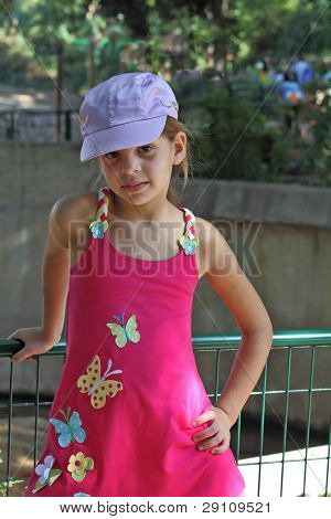 Sette-anno-ragazza dolce in un sarafan rosa guarniti appliqu? s sotto forma di farfalle e tappo raso