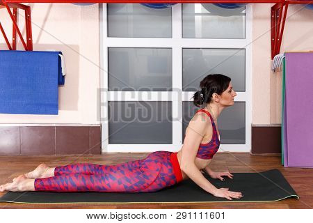 Young Sporty Woman Practicing Yoga, Doing Mahamudra Stretching Position In A Fitnes Club