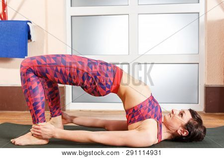 Young Sporty Woman Practicing Yoga, Doing Mahamudra Stretching Position In A Fitnes Club