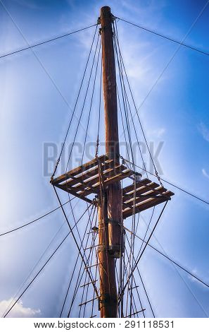 Wooden Ship Mast Against Blue Sky. Close Up