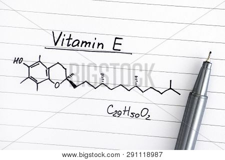 Chemical Formula Of Vitamin E On Lined Paper With Pen. Close-up.
