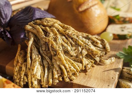 Smoked Cheese Pigtail, Traditional Polish Smoked Cheese, Chechil Cheese On The Wood Background. Smok