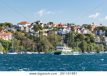 Ferry Boat With Yachts And Residential Houses On The Background. Cremorne Point, Sydney, Australia