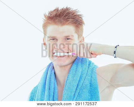 Reflection In A Bathroom Mirror Of  Young Man Brushing His Teet