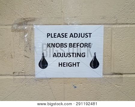Please Adjust Knobs Before Adjusting Height Sign With Boxing Bag On Wall
