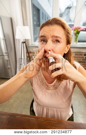Woman Using Nose Spray While Having Running Nose After Allergy