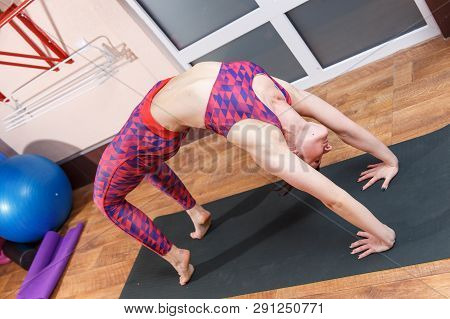 Young Sporty Woman Practicing Yoga, Doing Mahamudra Stretching Position In A Fitnes Club