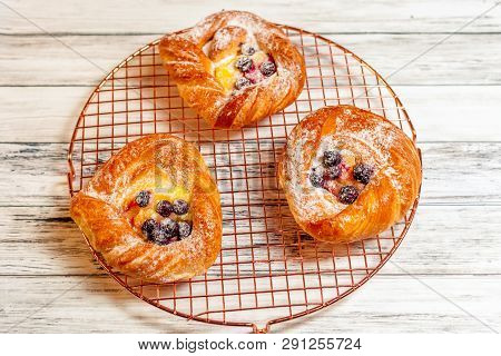 Top View Of Golden Chese Danish Pasties With Blackberries And Powder Sugar
