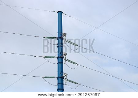 Power Line Support Against Blue Sky With White Clouds. High-voltage Electricity Transmission Line