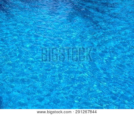The Water Surface Of The Swimming Pool Turquoise Color, Illuminated By The Sun