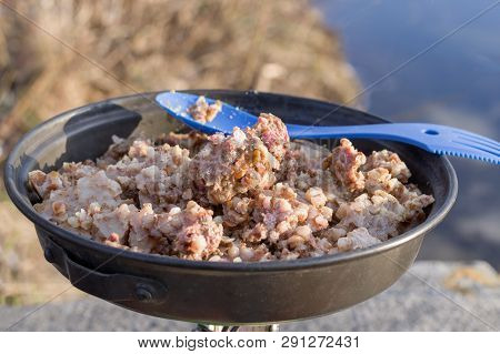 Buckwheat porridge in the pan. Buckwheat porridge with meat. Taste the food.