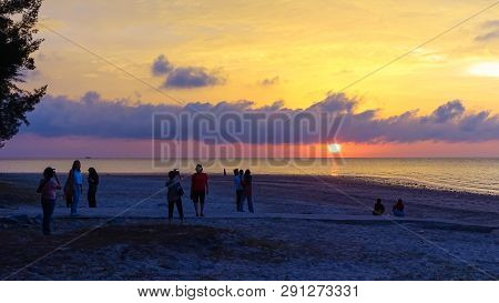 Labuan,malaysia-mac 9,2019:a Group Of People Gather To Watch The Sunset At Layang Layangan Beach In 