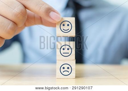 Hand Of A Businessman Chooses A Smiley Face On Wood Block Cube, The Best Excellent Business Services