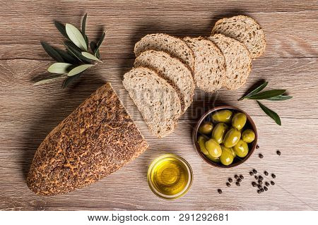 Bread With Olives And Olive Oil On A Wooden Table