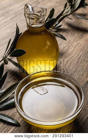 Olive Oil And Leaves On A Wooden Table