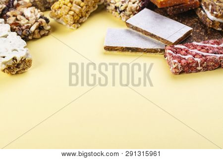 Assortment Of Different Granola Cereal Bars On Yellow Background. Healthy Pre Or Post Workout Snacks