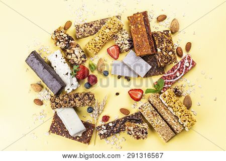 Assortment Of Different Granola Cereal Bars On Yellow Background. Healthy Pre Or Post Workout Snacks
