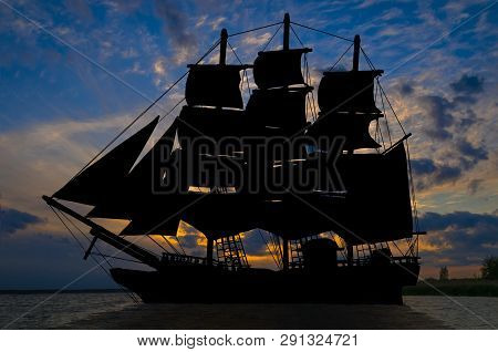 Old Ancient Pirate Ship Silhouette On Peaceful Ocean At Sunset Background