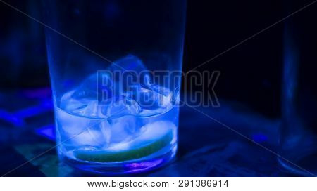 Almost Finished Cocktail - Bright Glass And Ice Cubes - Dark Background