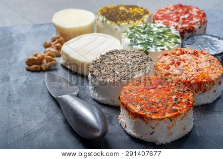Assortment Of French Fresh White Soft Goat Cheeses With Different Tastes Topping Made With Herbs, Pa