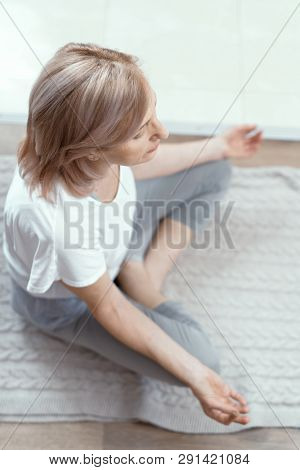 After Yoga A Woman Meditates. Age Of The Woman For 50 Years. She Has Been Doing Yoga At Home For A L