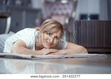 A Woman Between The Ages Of 50 And 60 Loves To Do Yoga. She Lies On The Floor Resting After Class. Y