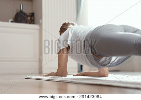 Adult Woman Does Yoga. She Conducts Classes At Home In The Living Room. The Woman Took The Position 