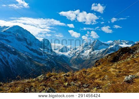 View From The Pass To The Mountain Valley With Snow-capped Veins.