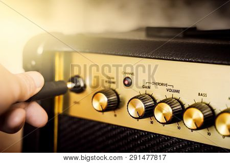 Guitar Electric Amplifier. Rock Overdrive Effect. Hand Is Plugging A Cable Into Jack. Max Volume Kno