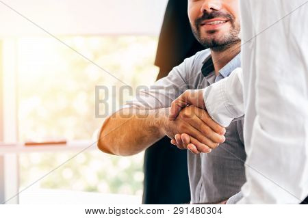Close-up Of Two Businessmen Shaking Hands Together In Indoor Office Environment - Business Greeting,