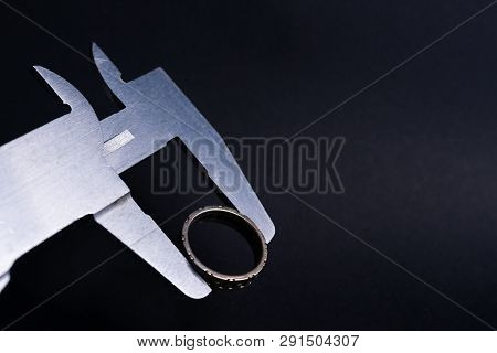 Vintage Steel Caliper Measuring Diameter Of Sterling Silver Male Ring Closeup. Ring In Focus. Tool I