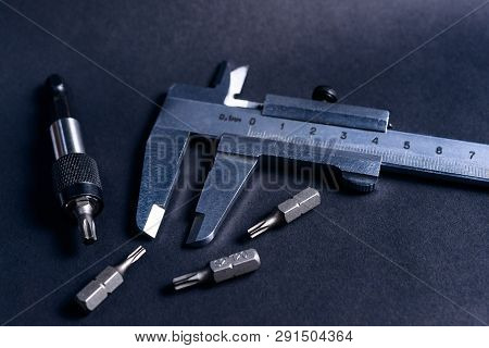 Vintage Steel Caliper With Modern Tool Bits And Bitholder On Dark Background. Caliper And Bitholder 