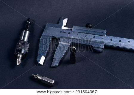 Vintage Steel Caliper With Modern Tool Bits And Bitholder On Dark Background. Caliper And Bitholder 
