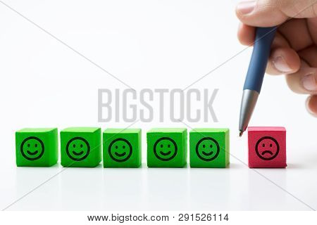 Hand Separate Single Sad Face From Many Smiling Faces To Avoid Negative Influence