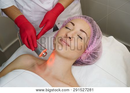 Ultrasound Chromotherapy. Hardware Cosmetology. Beautician Carries Out Procedure For Tightening Skin