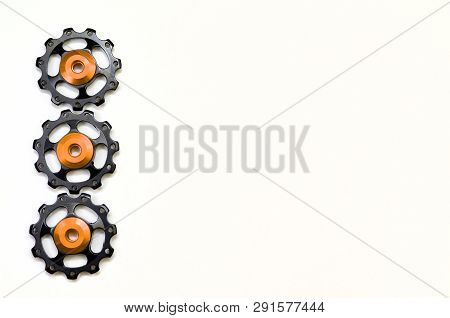 Color Rollers, Black, Golden Gears For Bicycle Rear Derailleur Isolated On White Background In Left 