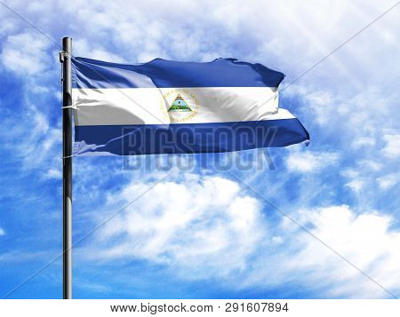 National Flag Of Nicaragua On A Flagpole In Front Of Blue Sky.