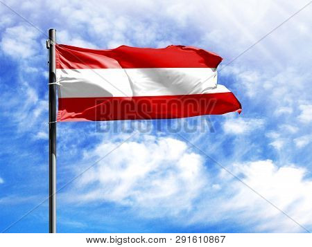 National Flag Of Austria On A Flagpole In Front Of Blue Sky.