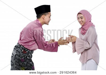 Portrait Of Young Man With Traditional Clothing Shaking Hand His Wife During Hari Raya Over White Ba